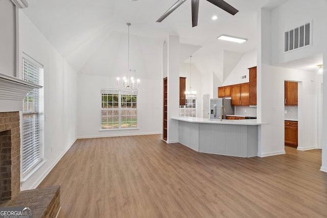 103 St Albans Way, Peachtree City, GA 30269 - unfurnished living room with visible vents, wood finished floors, a fireplace, high vaulted ceiling, and ceiling fan with notable chandelier
