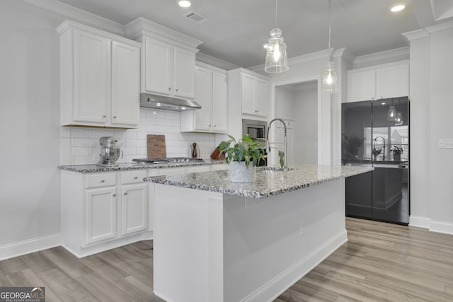 7108 Birch View Ct, Flowery Branch, GA 30542 - kitchen with appliances with stainless steel finishes, under cabinet range hood, white cabinets, light wood-style flooring, and recessed lighting