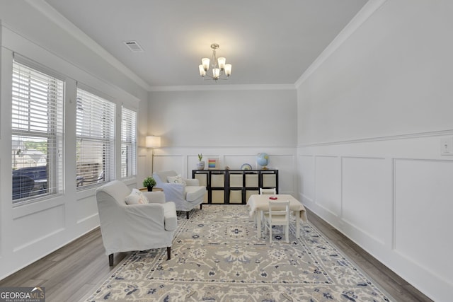 7108 Birch View Ct, Flowery Branch, GA 30542 - living area with a decorative wall, ornamental molding, a chandelier, wood finished floors, and wainscoting