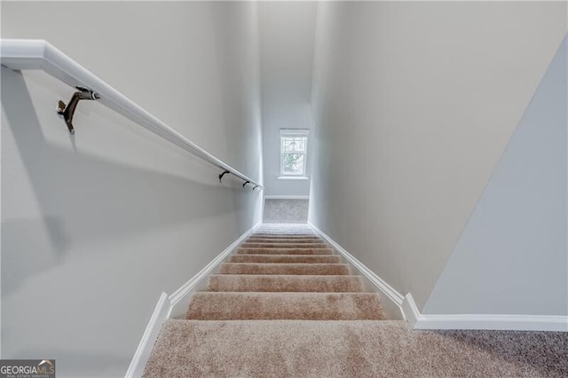 staircase featuring carpet floors and baseboards