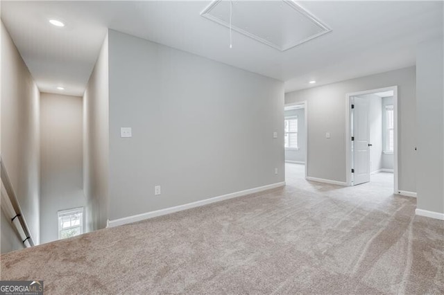 unfurnished room featuring attic access, carpet floors, baseboards, and recessed lighting