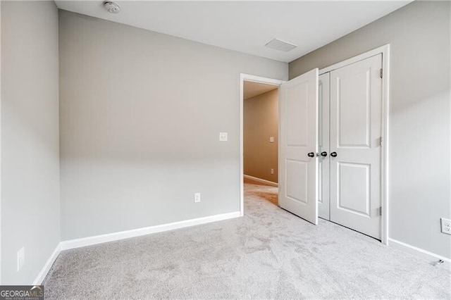 unfurnished bedroom with a closet, visible vents, carpet flooring, and baseboards