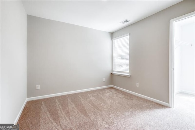 carpeted empty room with baseboards and visible vents