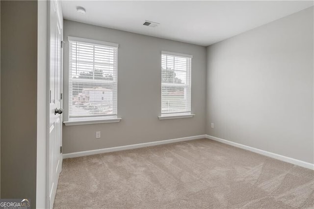 spare room with baseboards, visible vents, and carpet floors
