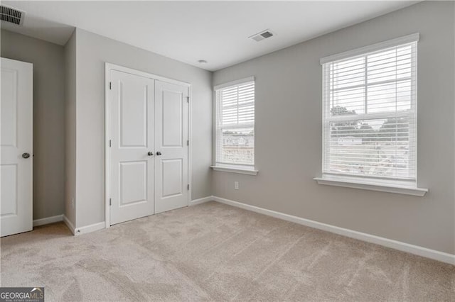 unfurnished bedroom with visible vents and carpet