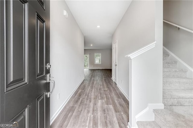 hall with recessed lighting, wood finished floors, baseboards, and stairway
