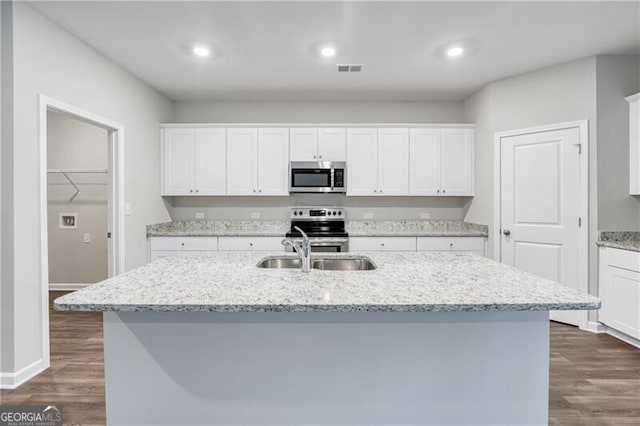 kitchen with visible vents, a sink, dark wood-style flooring, appliances with stainless steel finishes, and white cabinetry