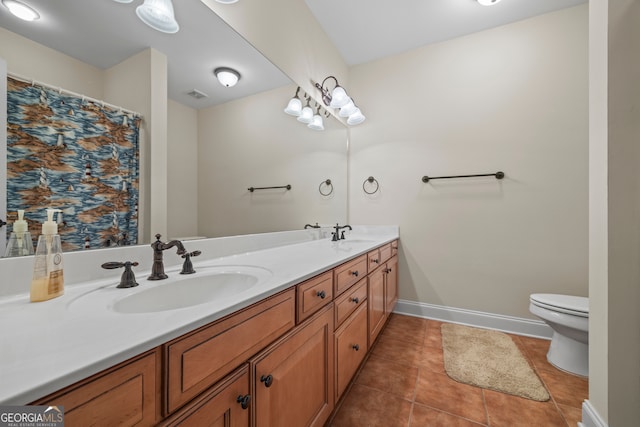 bathroom featuring tile patterned floors, a sink, double vanity, toilet, and visible vents