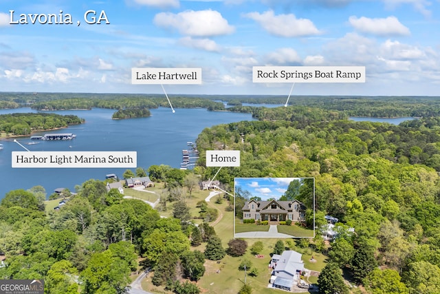 drone / aerial view with a forest view and a water view