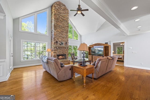 living room with a fireplace, wood finished floors, a ceiling fan, and high vaulted ceiling