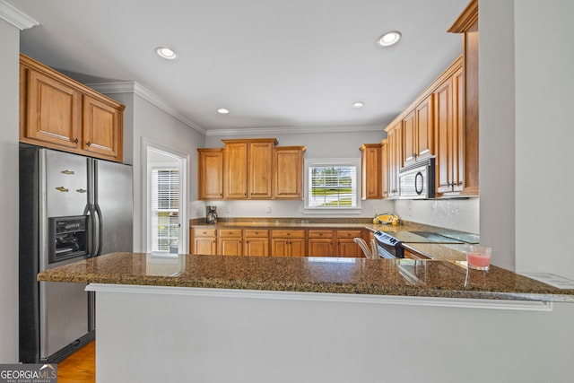 kitchen featuring crown molding, dark stone countertops, a peninsula, appliances with stainless steel finishes, and recessed lighting