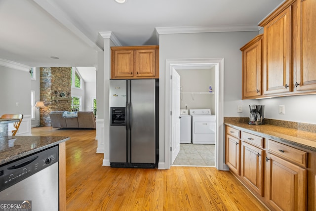 kitchen featuring ornamental molding, light wood-type flooring, separate washer and dryer, appliances with stainless steel finishes, and open floor plan