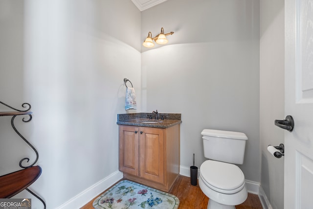 bathroom featuring toilet, vanity, and baseboards