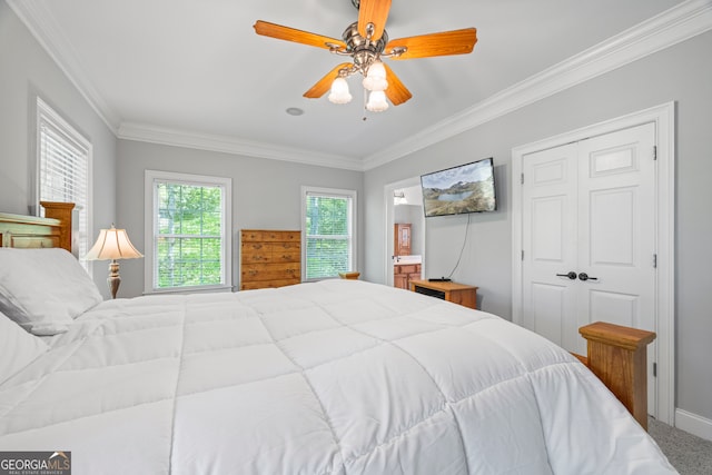 bedroom with carpet floors, ensuite bath, a ceiling fan, and ornamental molding