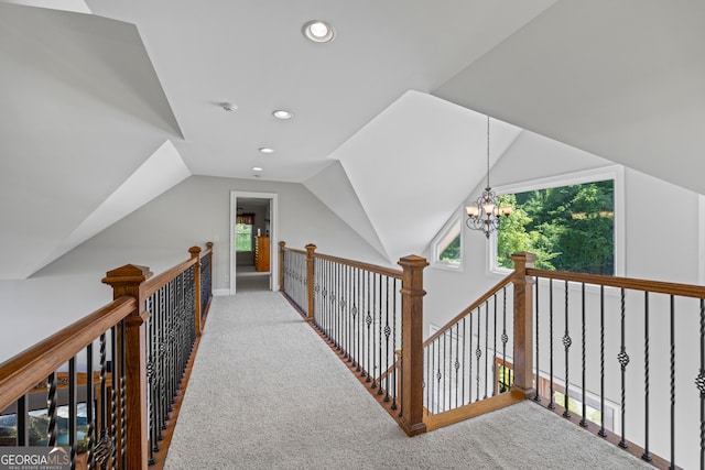 hall featuring recessed lighting, an inviting chandelier, vaulted ceiling, an upstairs landing, and carpet floors