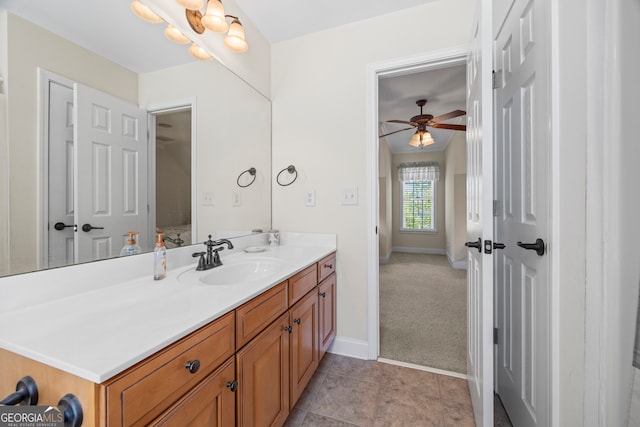 ensuite bathroom featuring ensuite bath, baseboards, a ceiling fan, and vanity