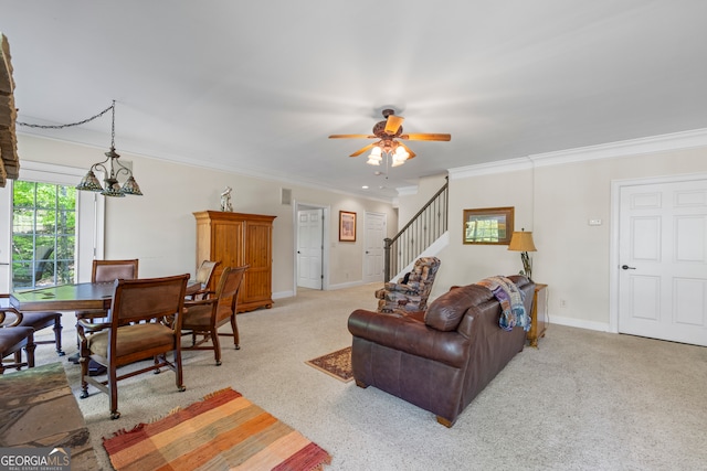 living room featuring stairway, light carpet, crown molding, baseboards, and ceiling fan with notable chandelier
