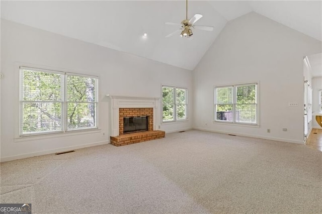 unfurnished living room with a ceiling fan, carpet floors, baseboards, a fireplace, and high vaulted ceiling