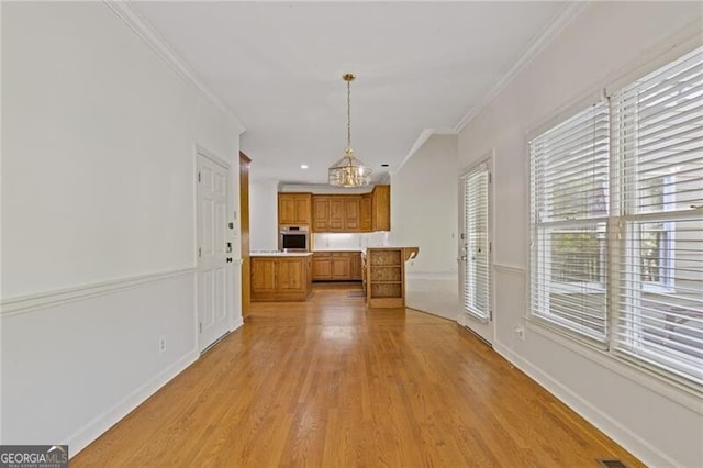 kitchen with brown cabinetry, oven, crown molding, and light countertops