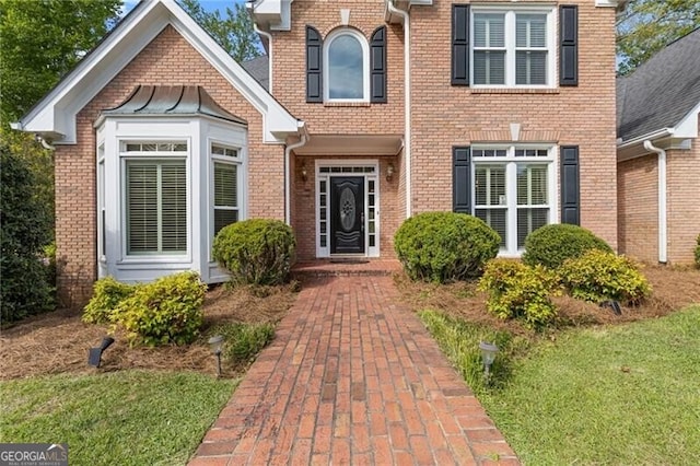 view of exterior entry featuring brick siding