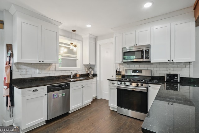 kitchen featuring backsplash, stainless steel appliances, dark wood-style floors, and a sink