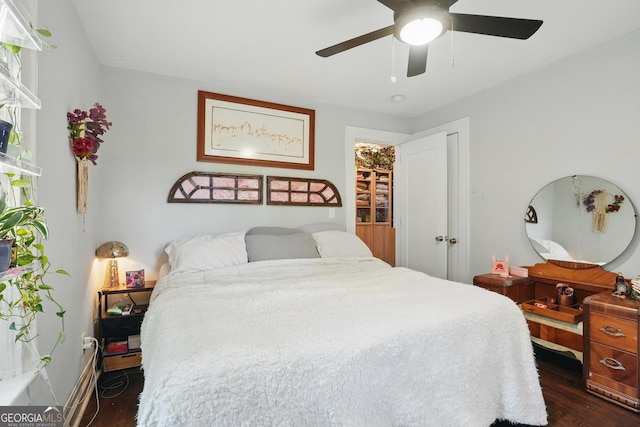 bedroom with a ceiling fan, baseboards, and dark wood-type flooring