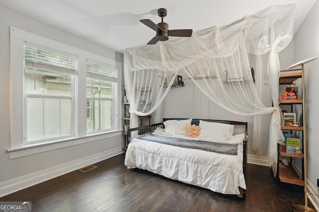 bedroom featuring baseboards, ceiling fan, wood finished floors, and visible vents