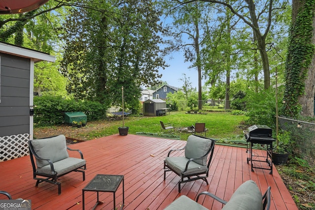 deck with an outdoor structure, a fenced backyard, area for grilling, a storage unit, and a yard