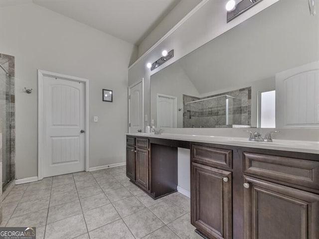 full bath with lofted ceiling, tile patterned flooring, double vanity, a sink, and a stall shower