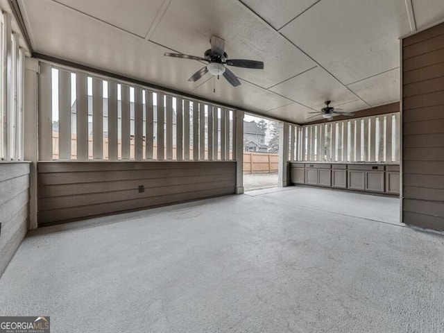 unfurnished sunroom with a ceiling fan