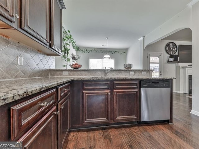 kitchen with dishwasher, dark wood-style flooring, light stone countertops, and a sink