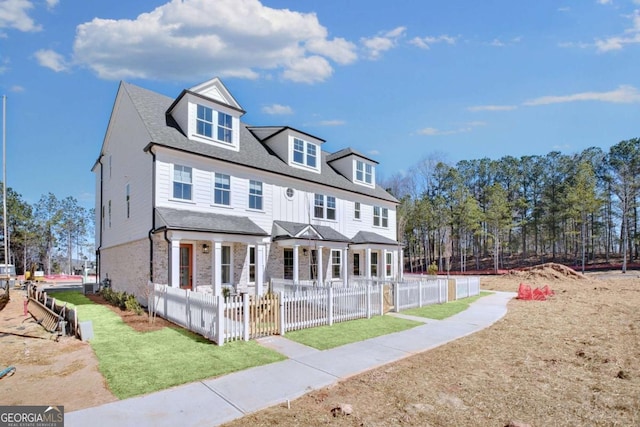 back of house with covered porch and a fenced front yard