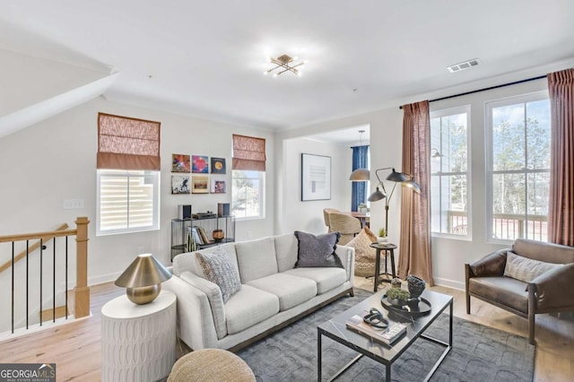 living room with plenty of natural light, visible vents, and light wood-type flooring