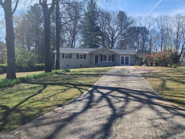 single story home featuring french doors, driveway, and a front yard