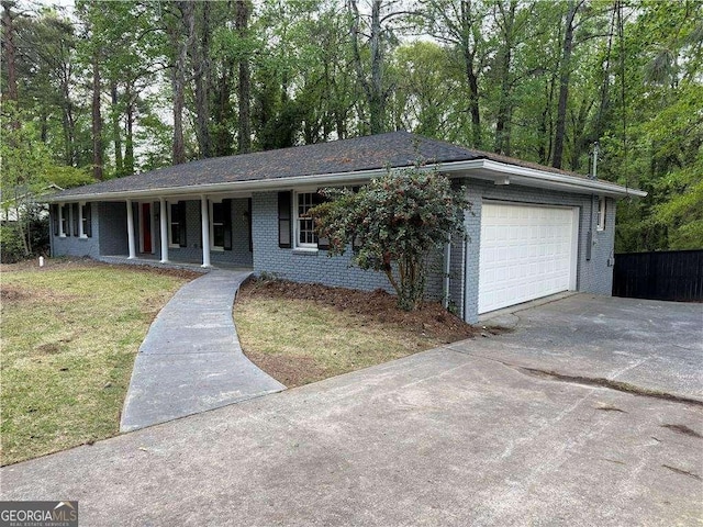 ranch-style house with driveway, covered porch, an attached garage, a front yard, and brick siding