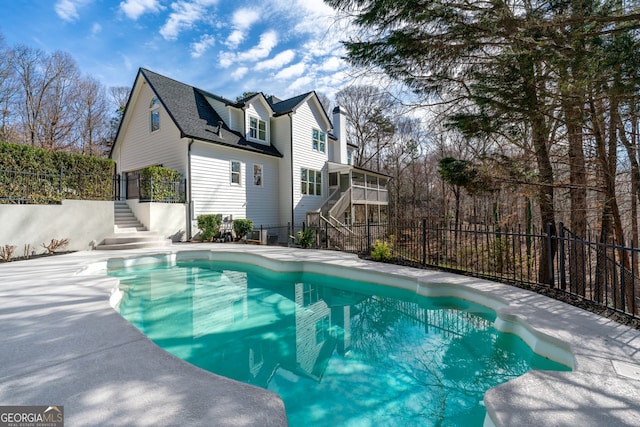 view of swimming pool featuring a fenced in pool, stairway, and fence