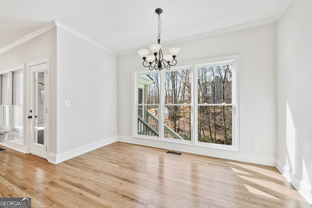 unfurnished dining area with baseboards, light wood-style flooring, visible vents, and a chandelier