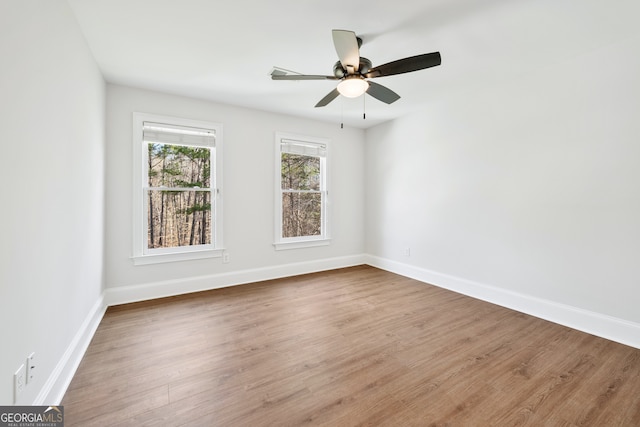 unfurnished room with wood finished floors, baseboards, and a ceiling fan