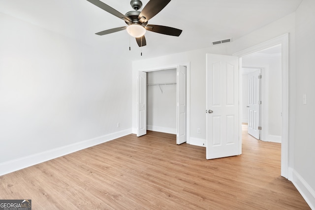 unfurnished bedroom with a closet, light wood-style floors, visible vents, and baseboards
