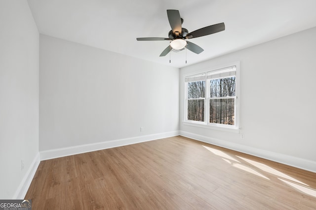 unfurnished room with light wood finished floors, baseboards, and ceiling fan