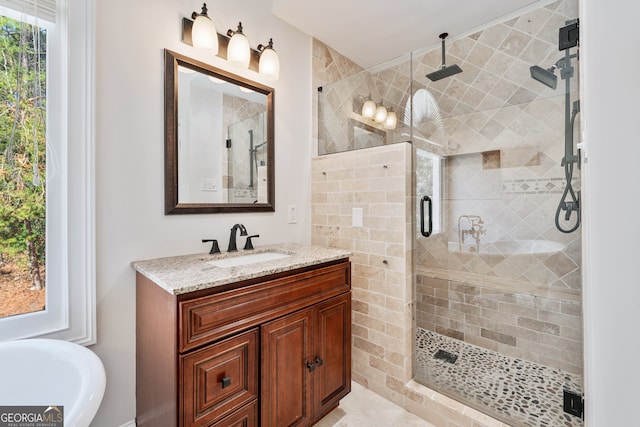 bathroom with a freestanding bath, vanity, and a stall shower