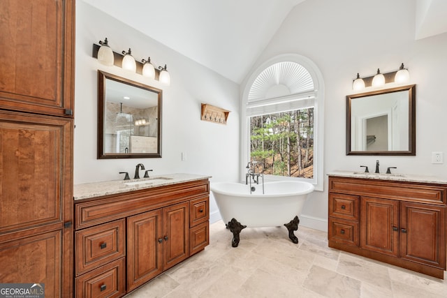 bathroom with vaulted ceiling, two vanities, a soaking tub, and a sink