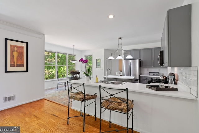 1820 Lyon Ave SW, Atlanta, GA 30331 - kitchen featuring stainless steel appliances, gray cabinetry, recessed lighting, light countertops, and a kitchen bar