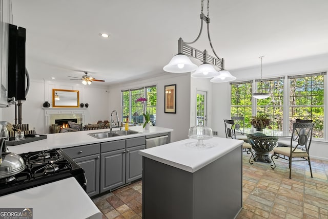 1820 Lyon Ave SW, Atlanta, GA 30331 - kitchen with gray cabinets, gas stove, ceiling fan, a warm lit fireplace, and a kitchen island