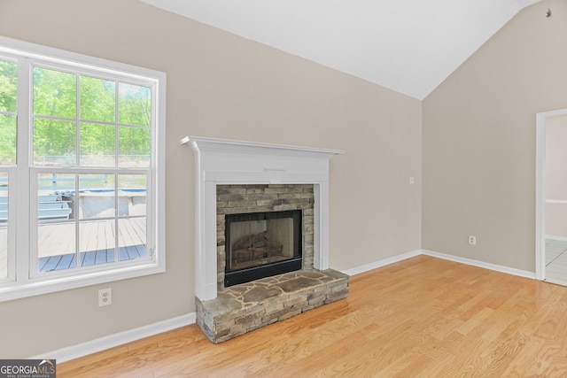 120 Hidden Brook Trl, Newnan, GA 30265 - unfurnished living room featuring wood finished floors, lofted ceiling, and a stone fireplace