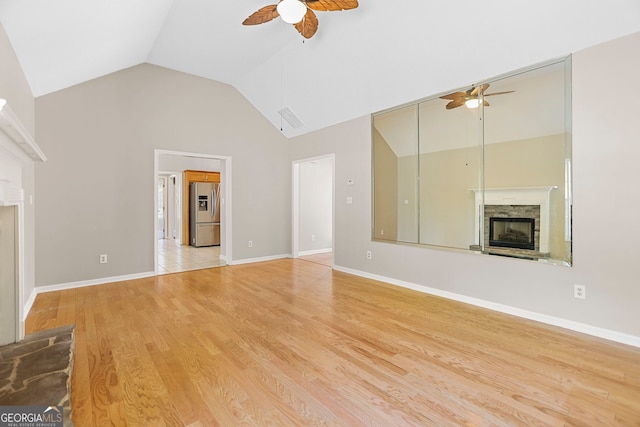 120 Hidden Brook Trl, Newnan, GA 30265 - unfurnished living room with ceiling fan, a stone fireplace, light wood-style flooring, and high vaulted ceiling