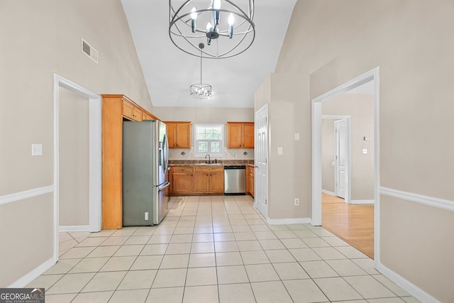 120 Hidden Brook Trl, Newnan, GA 30265 - kitchen featuring appliances with stainless steel finishes, a chandelier, light tile patterned flooring, high vaulted ceiling, and decorative light fixtures