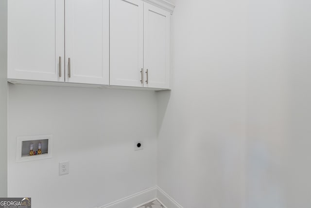 washroom featuring electric dryer hookup, cabinet space, hookup for a washing machine, and baseboards