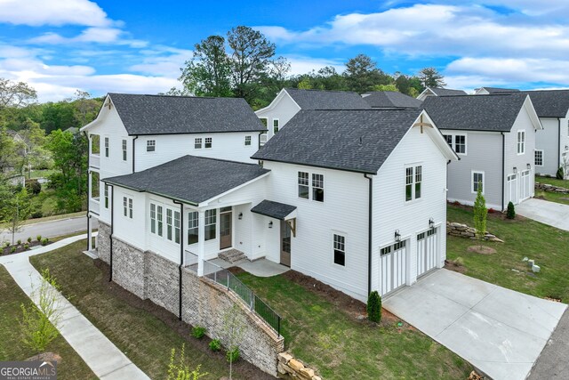 rear view of property featuring driveway, fence, a yard, a garage, and roof with shingles