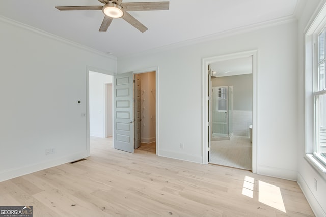 unfurnished bedroom featuring a walk in closet, baseboards, wood finished floors, and ornamental molding